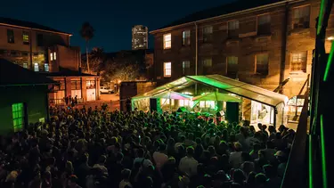 An audience watching a stage with neon strobe lights.