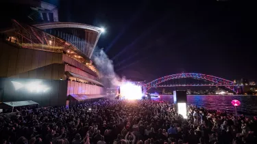 The crowd of people in the forecourt of Sydney opera house gathered for a concert.