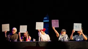 All five judges raising their score cards in the air.