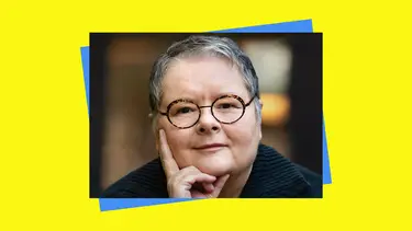 Magda Szubanski wearing glasses with one hand resting on her face