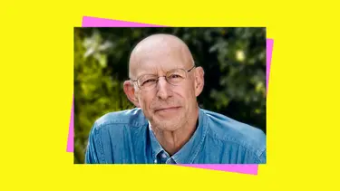 A man wearing a blue denim shirt and spectacle glasses thinking and smiling