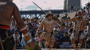 Men in sand pit performing indigenous dance in the Homeground of Sydney opera house.