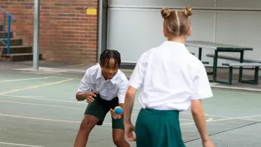 A young girl and boy playing on the playground.