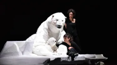 A mother and a cub polar bear puppet standing on a small block of ice.
