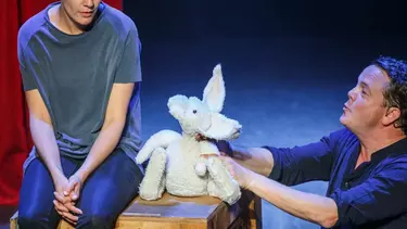 Two men performing with a soft toy.