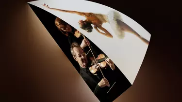 A man and a woman playing violin with a ballerina doing ballet.