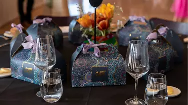 Glasses and wrapped packages resting on a decorated table.