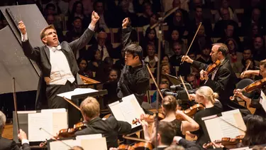 A conductor giving instructions to the orchestra.