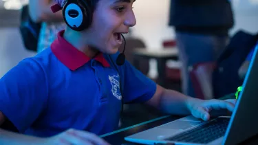 A boy on computer wearing a headset.