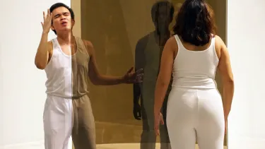 Performers interacting with translucent screens in an art gallery.