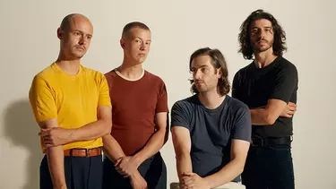 Four men wearing t-shirts.