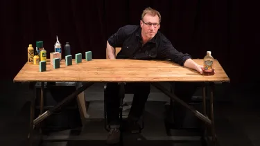 A man displays items on a tabletop.