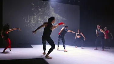 A group of six dancers performing on stage