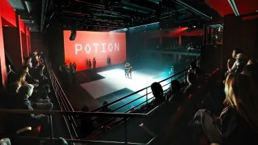 Audience watching performers on stage under lights