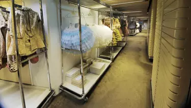 Clothes and shoes on a movable clothes rack.