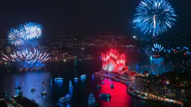 Blue and red fireworks over Sydney Harbour and the Sydney Opera House.