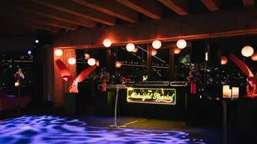 A bar at night with lights around it and a neon sign The Midnight Special, with the Sydney Harbour Bridge in the background.