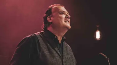 Bryn Terfel stands in front of a microphone.