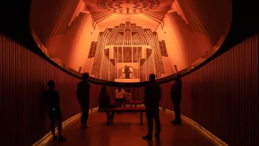 A group of people in a room watching a projection of a show.