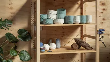A selection of colored bowls and pots stacked on a wooden cabinet.