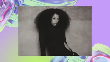 A young, black woman with voluminous curly hair poses wearing a sleek black outfit. The background is a purple, iridescent swirl, looking like water.