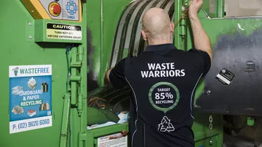 A man using a cardboard compactor.