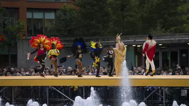 7 people in costume walking on a yellow outdoor catwalk.