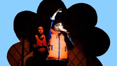 A person holds up a small toy, shining a torch on it.