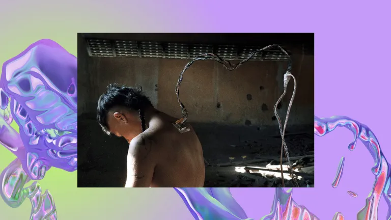 A person is standing with their head down. They have an outlet with wires connected on their upper back.