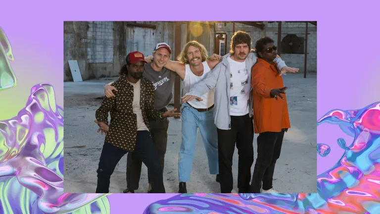 The five members of King Stingray stand with their arms around each other in an abandoned lot.