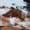 A misty brown mountain with a path leading up it