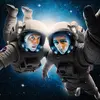 Two men in astronaut suits float in space.