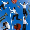 Circus performers in white shirts and black pants are superimposed on a blue background surrounded by instruments.