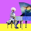 A man wearing a Mozart costume and a big white wig sitting at a grand piano