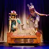 Two characters jump over a couch wearing cardboard boxes on their heads.