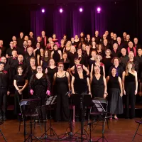 A group of people wearing black standing in rows on stage.