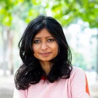 An Australian, Indian women with curled black hair.