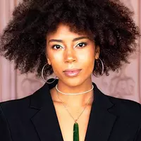 A woman with Afro hair wearing a black suit jacket.