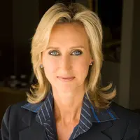 Portrait of Janine Perrett smiling. She is wearing formal business attire.