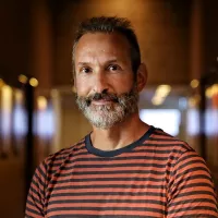 A man with grey hairs and beard.