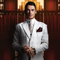 Portrait of Spencer Craig from the waist up, wearing a light grey suit standing in front of a bar.