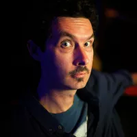 A man with moustache and eyes wide open.