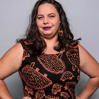 A woman wearing a dress with orange pattern.