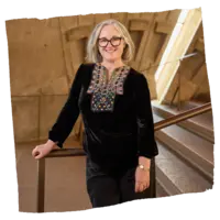 A woman standing inside the Sydney Opera House, leaning on a handrail.