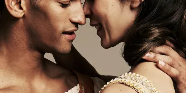 A man and woman are embracing with their faces close together.