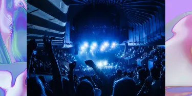 A crowd watching a performance inside the Sydney Opera House Concert Hall from the back of the theatre.