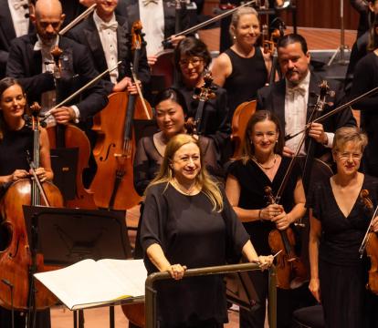 Conductor Simone Young stands with the Sydney Symphony Orchestra as they receive applause