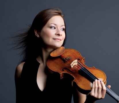 A woman with brown hairs holding a violin.