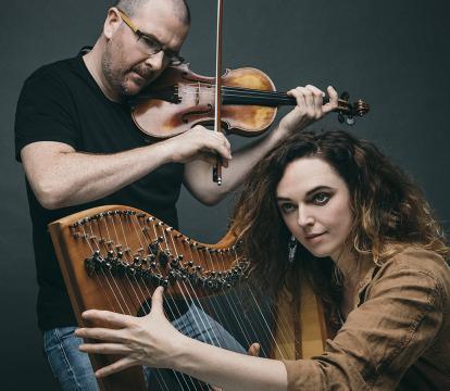A man playing a violin and a woman playing a harp.