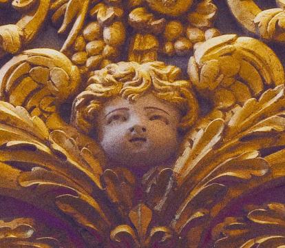 A golden cherub and flowers wood carving.